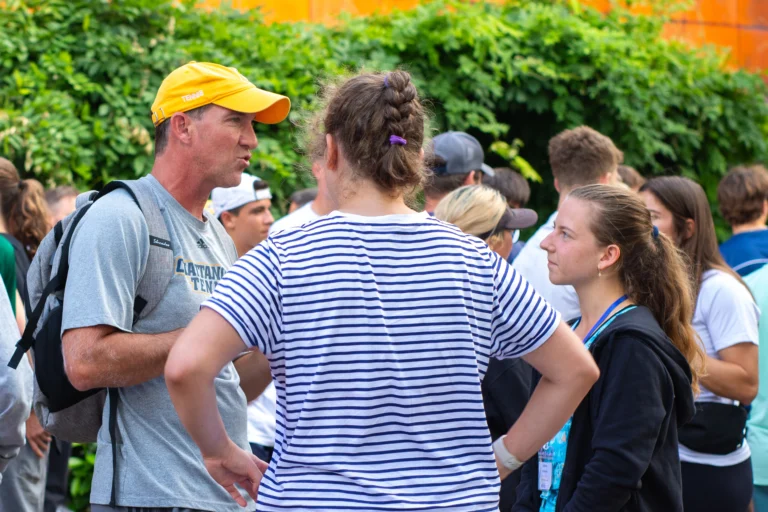 College coach talking to tennis players at showcase