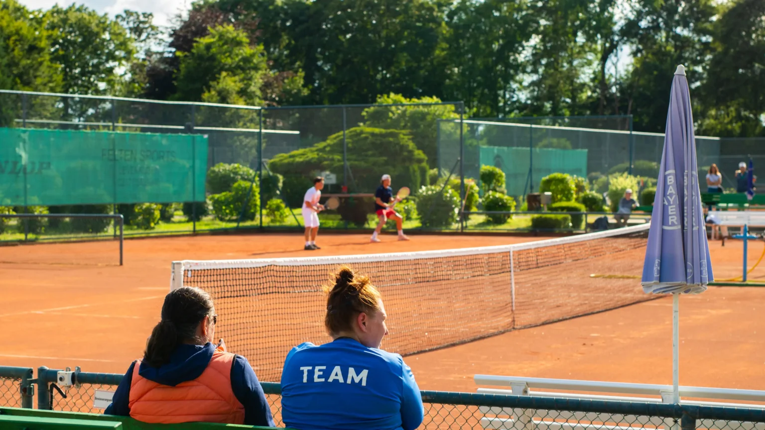 american university coaches watching tennis players