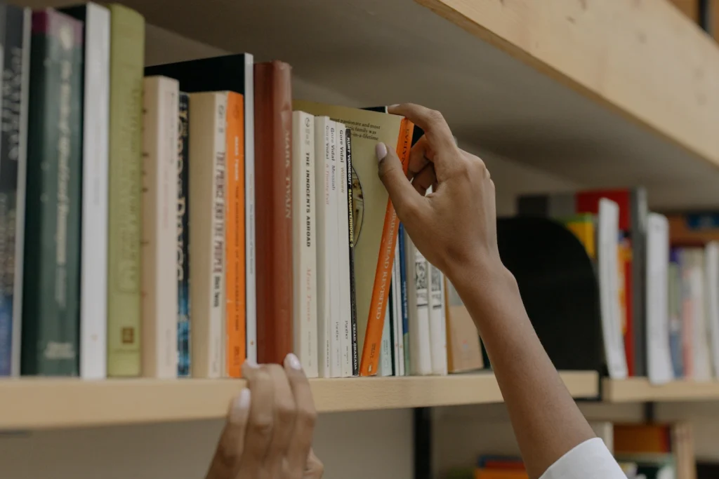Estudiante eligiendo un libro de una estantería.
