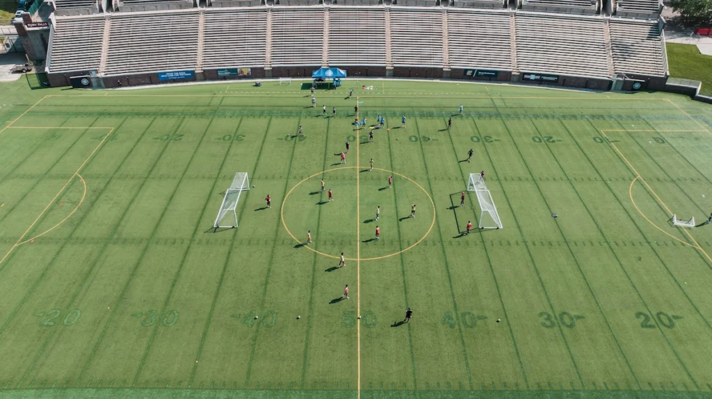 College soccer team training on the pitch during preseason practice session