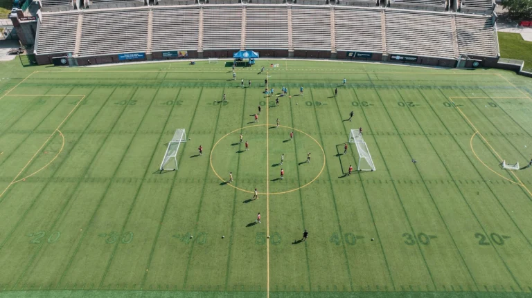 College soccer team training on the pitch during preseason practice session