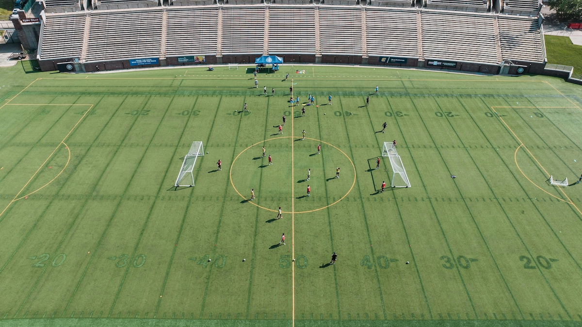 College soccer team training on the pitch during preseason practice session