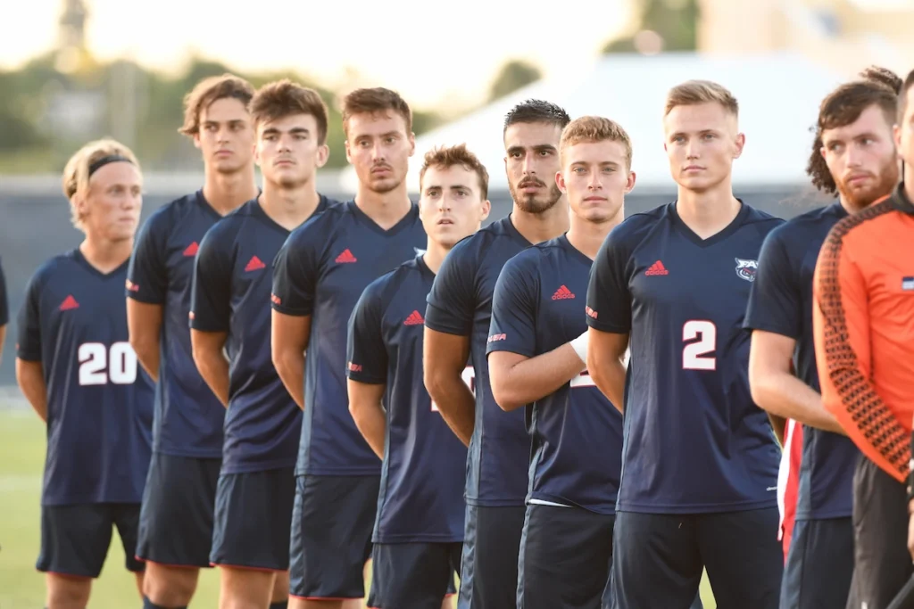 College football team lining up for the national anthem.