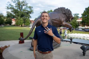 College swimmer Jan Delkeskamp showing his championship rings.