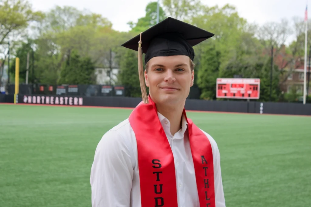 Student-athlete Tobias Wangerud taking his graduation pictures at the soccer field
